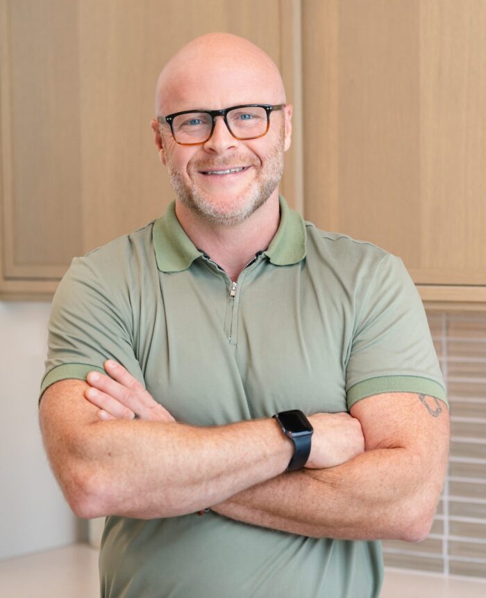 a headshot of a man named Henry who is wearing dark glasses and a green collared shirt