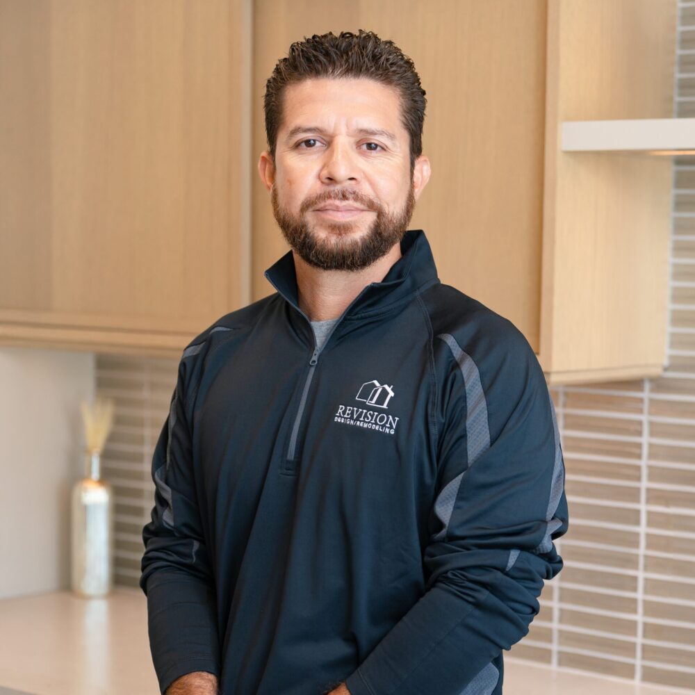 a headshot of a hispanic man named Walter who has his hands crossed and is wearing a black zip-up