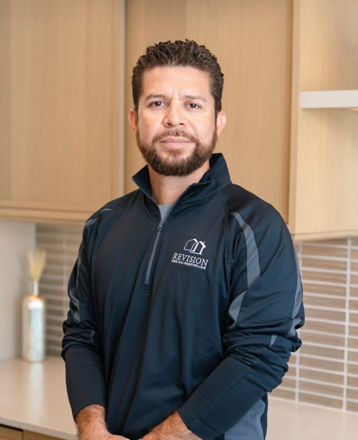 a headshot of a hispanic man named Walter who has his hands crossed and is wearing a black zip-up