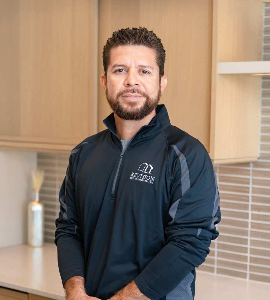 a headshot of a hispanic man named Walter who has his hands crossed and is wearing a black zip-up
