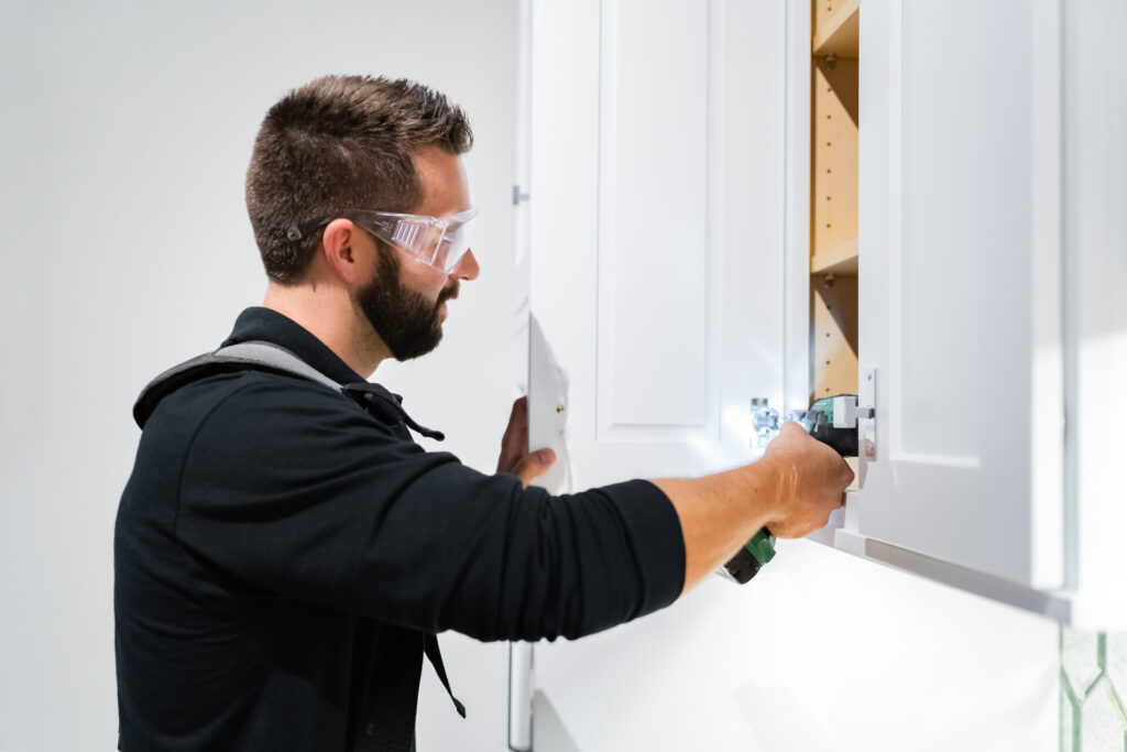 Craftsmen making final tweaks on a cabinet install in Myers Park
