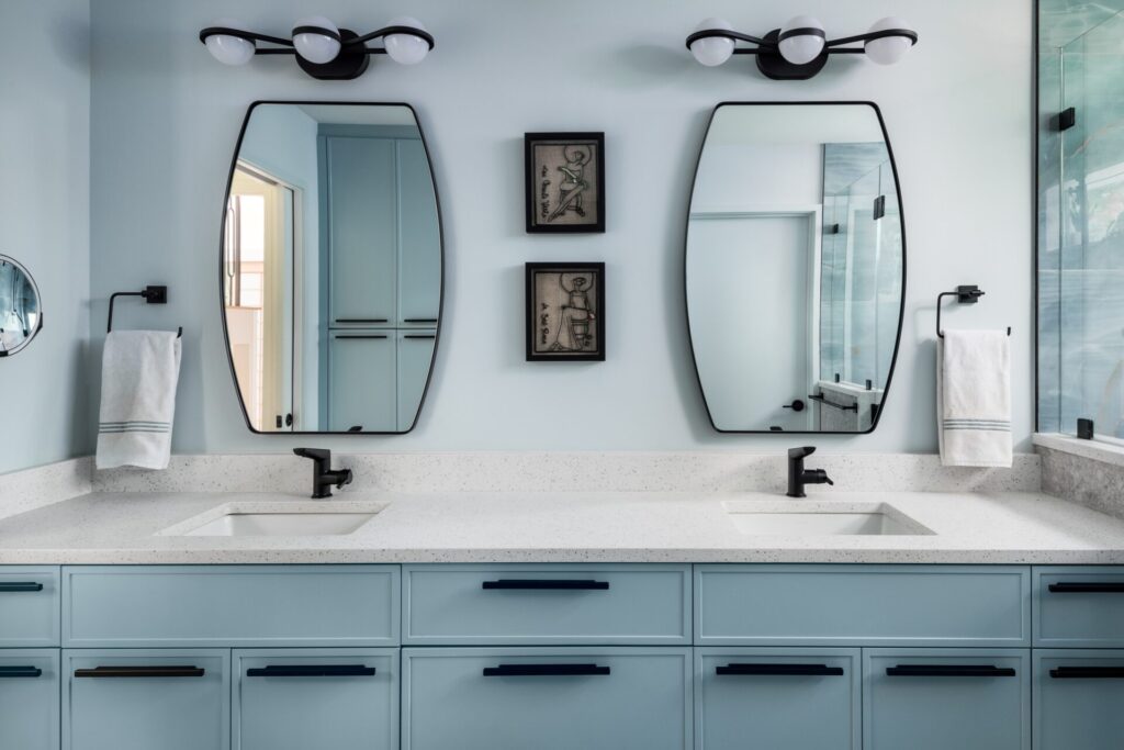 Slim shaker cabinets in a bathroom with a double vanity and black hardware.