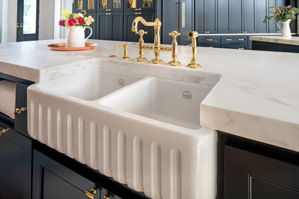 Shiny porcelain fluted, apron front sink with gold kitchen hardware