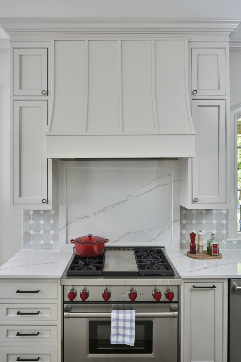 A marble backsplash as the background of a kitchen hood range in Charlotte, NC designed by Revision.