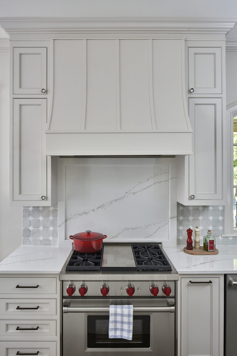 A marble backsplash as the background of a kitchen hood range in Charlotte, NC designed by Revision.