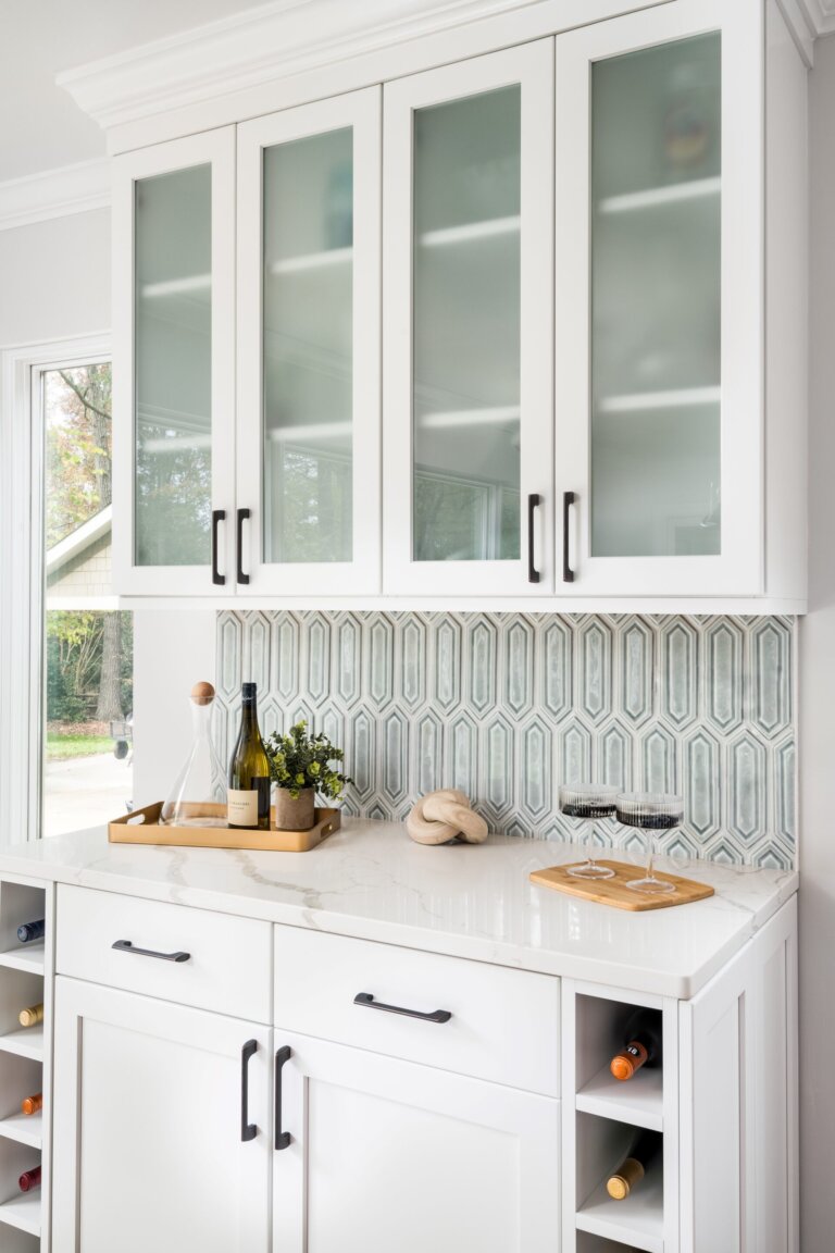 wet bar with frosted glass cabinets and two poured glasses of wine