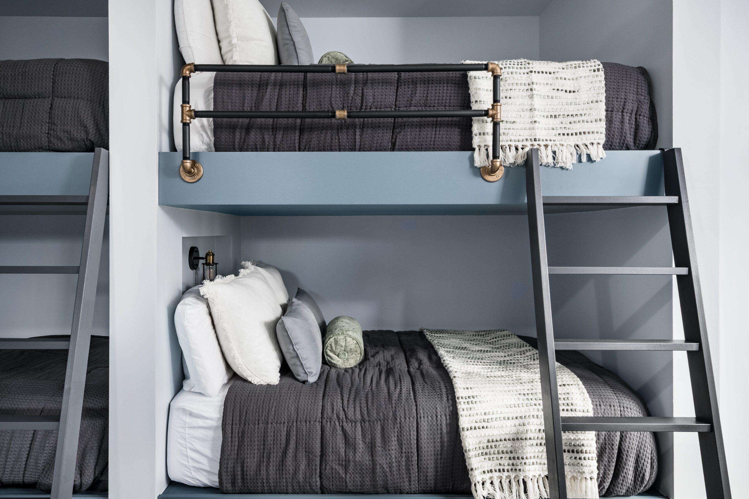 bunk beds with a wooden ladder and metal railings in a carmel forest home