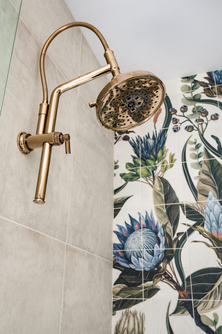 gold shower head in a primary walk-in shower